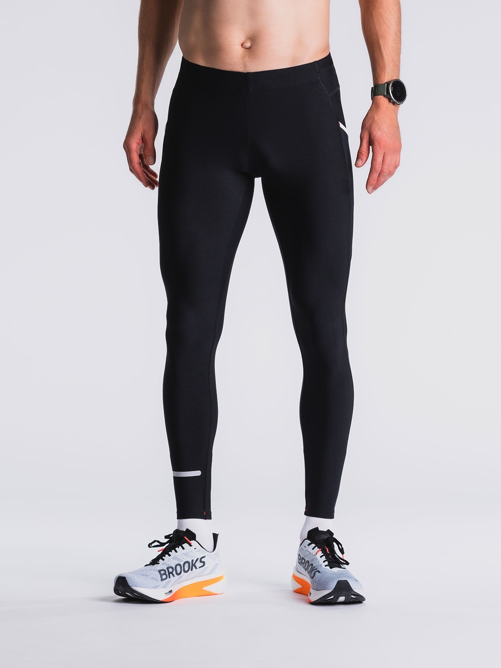 schwarzen Fusion C3 Long Tights an einem männlichen Model – enganliegend, mit dezentem Reflexstreifen am Beinabschluss